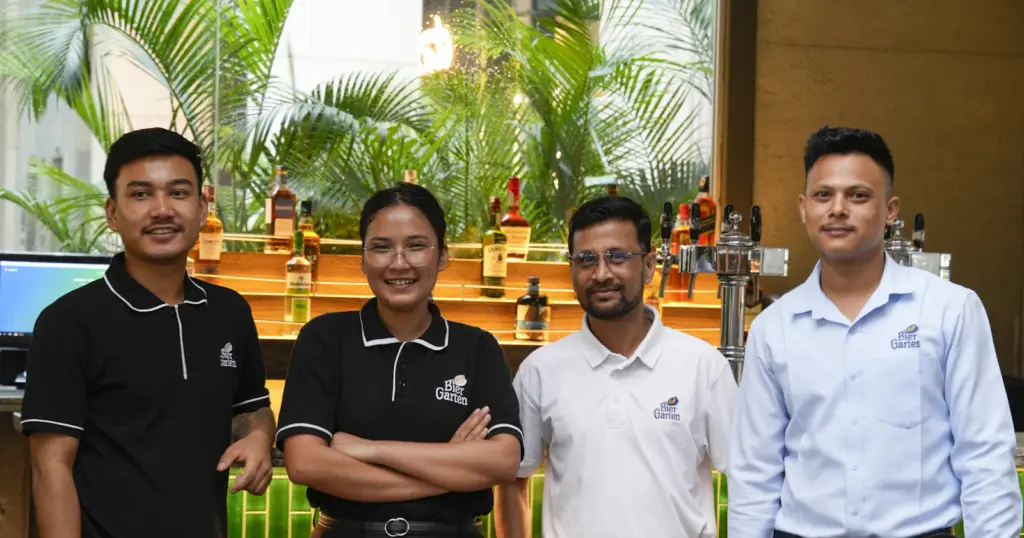 Équipe souriante en polos et chemises devant un comptoir